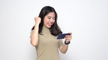 Beautiful Asian Woman playing mobile game on smartphone while standing Isolated On White Background video