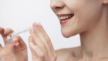 A woman with a beautiful smile and healthy teeth wears an orthodontic silicone trainer. This invisible aligner showcases a modern approach to orthodontics and confidence in her appearance video