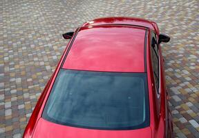 Ongoing View From Above On Red Vehicle Staying On Pavement photo
