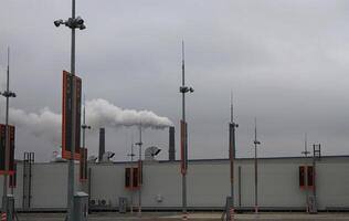 Contaminated Air Over Rooftop Vehicle Park With Smoking Stacks On Background photo