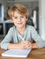 Portrait of a smiling boy doing homework at a table. photo