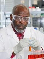 Male technician analyzing test tubes in laboratory setting photo