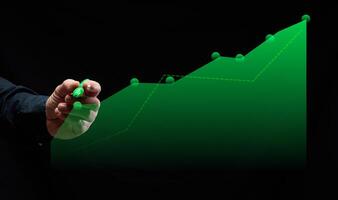 Graph with growing indicators and male hand with green marker on black background photo