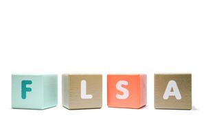 text FLSA Fair Labor Standards Act on colorful wooden isolated on a white background photo