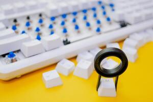 Remove mechanical keyboard keycap with tool on yellow background photo