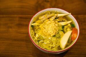 Soto ayam is a typical Indonesian food in the form of a type of chicken soup with a yellowish sauce photo