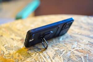 black phone case for smartphone with stand feature on table photo