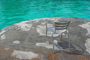 the swimming pool is clean and the rest chairs are empty photo
