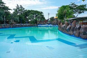 The swimming pool is equipped with various water rides, one of which is an artificial wave ride photo