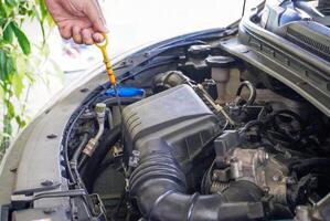 a hand checking the oil level in the engine before a trip or tri photo