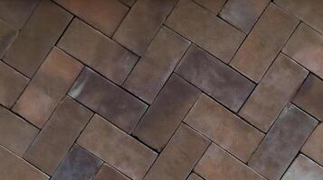 Close-up of Brown Interlocking Brick Floor Pattern with a Rustic Herringbone Design Showing Subtle Weathered Textures and a Matte Finish in Warm Earthy Tones photo