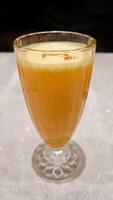 Freshly Squeezed Orange Juice in Elegant Glass on Marble Table with Soft Lighting Background photo