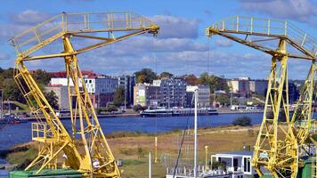 Szczecin, Poland. 14 September 2024. Landscape view and ships on the Odra river and old cranes photo