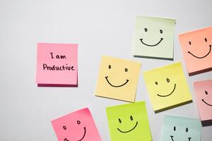 I am productive and smile emoticon on sticky notes. Motivational words for personal development, inspirational handwriting. Isolated on background photo