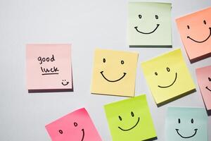 Good Luck and smile emoticon on sticky notes. Motivational words for personal development, inspirational handwriting. Isolated on background photo