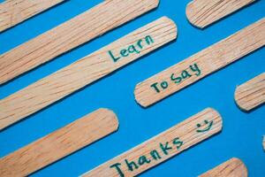 stick of ice cream with the words Learn to say Thanks. Motivational quotes, optimism, positive words. Isolated on background photo