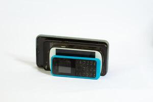 several phones tilted and photographed close up from a side angle with an isolated background photo