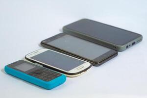 Mobile phones neatly arranged in a row and photographed from a side angle photo