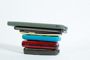 stack of mobile phones photographed close up from a side angle with isolated background photo