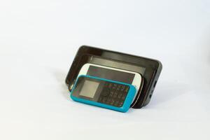 several phones tilted and photographed close up from a side angle with an isolated background photo