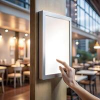 Self service screen mockup. Hand pointing at vertical white blank touch screen kiosk or tablet for food ordering or restaurant menu promotion information advertising design. photo