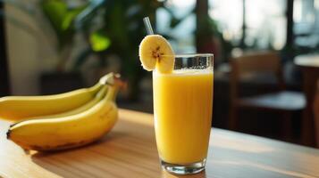A glass of orange juice with a banana on the side photo