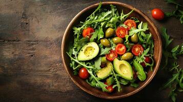 A bowl of salad with tomatoes, avocado and green olives photo