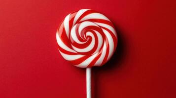 A red and white candy lollipop on a red background photo