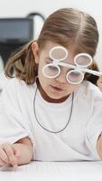 A young girl is practicing her vision skills in a state-of-the-art ophthalmology clinic. Engaging tools and a friendly atmosphere make the experience both fun and beneficial for her development video