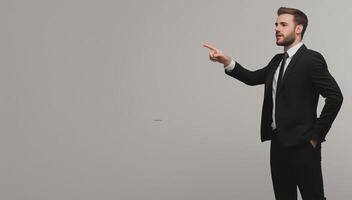 Businessman in Black Suit Pointing on Isolated Gray Background - Professional Corporate Concept photo