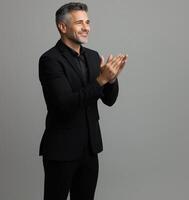 Professional Man in Black Suit Clapping on Isolated Gray Background - Business Success and Appreciation Concept photo