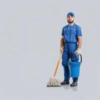 Professional Janitor in Blue Uniform Holding Mop and Bucket on Isolated Background photo