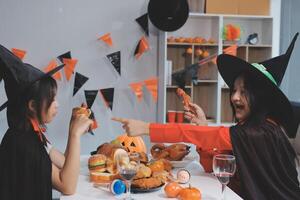 friendship, holiday and people concept - group of happy smiling friends in halloween costumes of vampire, devil, witch and cheetah at home party photo