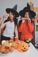 friendship, holiday and people concept - group of happy smiling friends in halloween costumes of vampire, devil, witch and cheetah at home party photo