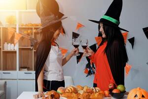 friendship, holiday and people concept - group of happy smiling friends in halloween costumes of vampire, devil, witch and cheetah at home party photo