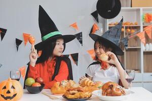 friendship, holiday and people concept - group of happy smiling friends in halloween costumes of vampire, devil, witch and cheetah at home party photo