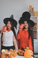 friendship, holiday and people concept - group of happy smiling friends in halloween costumes of vampire, devil, witch and cheetah at home party photo