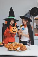 friendship, holiday and people concept - group of happy smiling friends in halloween costumes of vampire, devil, witch and cheetah at home party photo