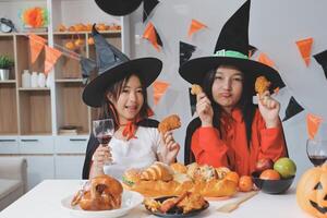 friendship, holiday and people concept - group of happy smiling friends in halloween costumes of vampire, devil, witch and cheetah at home party photo