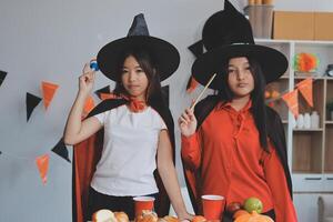 friendship, holiday and people concept - group of happy smiling friends in halloween costumes of vampire, devil, witch and cheetah at home party photo