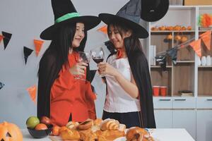friendship, holiday and people concept - group of happy smiling friends in halloween costumes of vampire, devil, witch and cheetah at home party photo