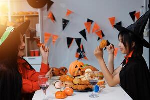 friendship, holiday and people concept - group of happy smiling friends in halloween costumes of vampire, devil, witch and cheetah at home party photo