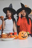 friendship, holiday and people concept - group of happy smiling friends in halloween costumes of vampire, devil, witch and cheetah at home party photo