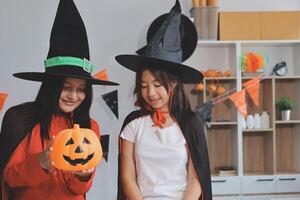 friendship, holiday and people concept - group of happy smiling friends in halloween costumes of vampire, devil, witch and cheetah at home party photo