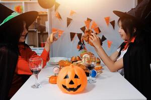 friendship, holiday and people concept - group of happy smiling friends in halloween costumes of vampire, devil, witch and cheetah at home party photo