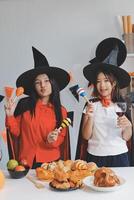 friendship, holiday and people concept - group of happy smiling friends in halloween costumes of vampire, devil, witch and cheetah at home party photo