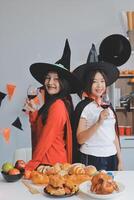 friendship, holiday and people concept - group of happy smiling friends in halloween costumes of vampire, devil, witch and cheetah at home party photo