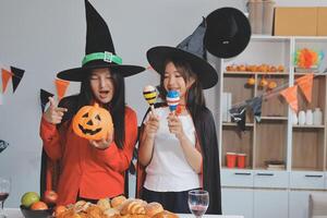 friendship, holiday and people concept - group of happy smiling friends in halloween costumes of vampire, devil, witch and cheetah at home party photo