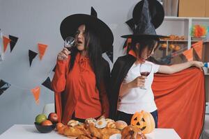 friendship, holiday and people concept - group of happy smiling friends in halloween costumes of vampire, devil, witch and cheetah at home party photo