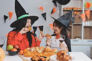 friendship, holiday and people concept - group of happy smiling friends in halloween costumes of vampire, devil, witch and cheetah at home party photo